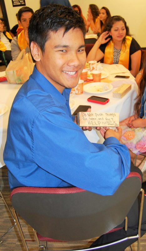 A man in blue shirt sitting and smiling